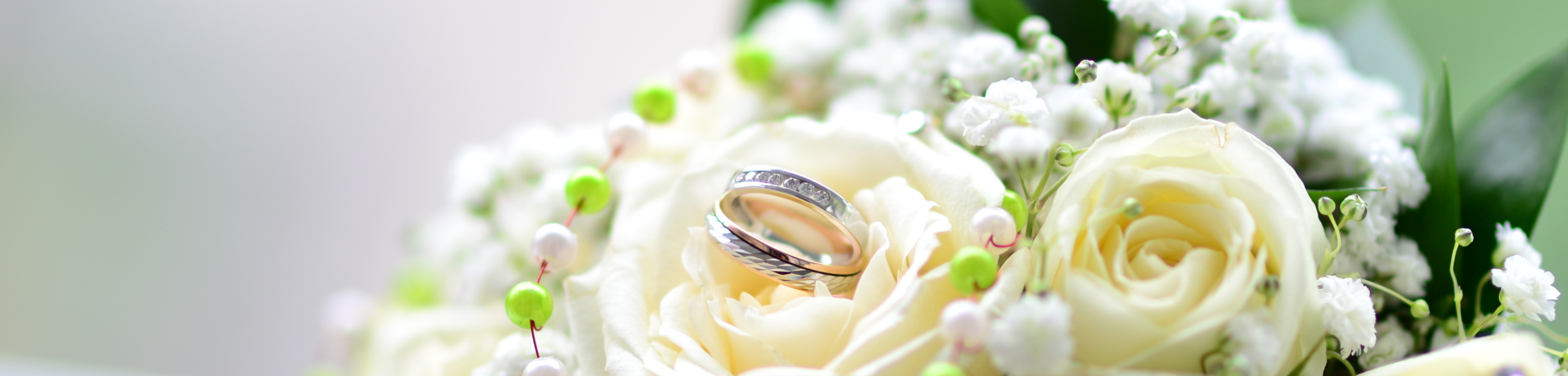 Wedding rings in white rose bouquet
