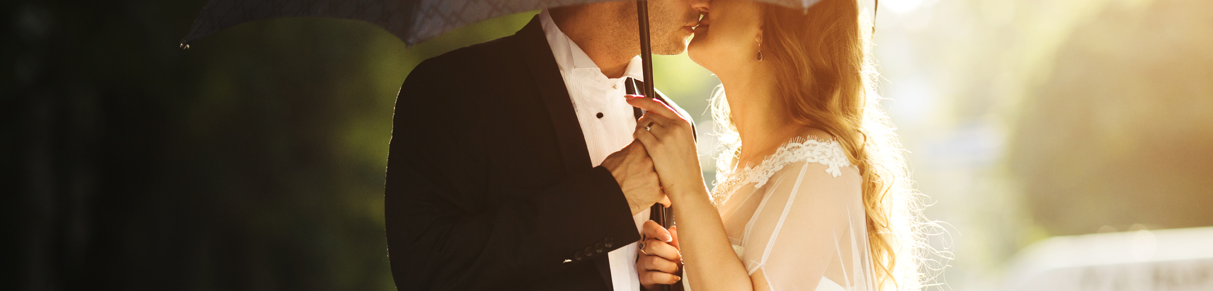 Wedding couple kissing on umbrella